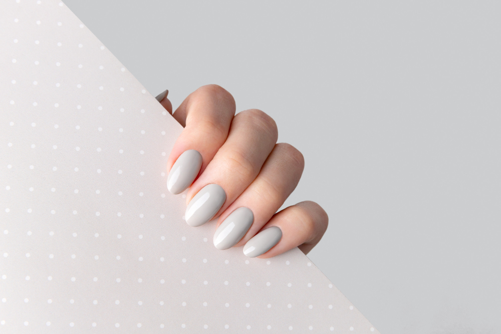 beautiful-womans-hand-with-manicure-close-up-polka-dot-background-gray-nail-polish